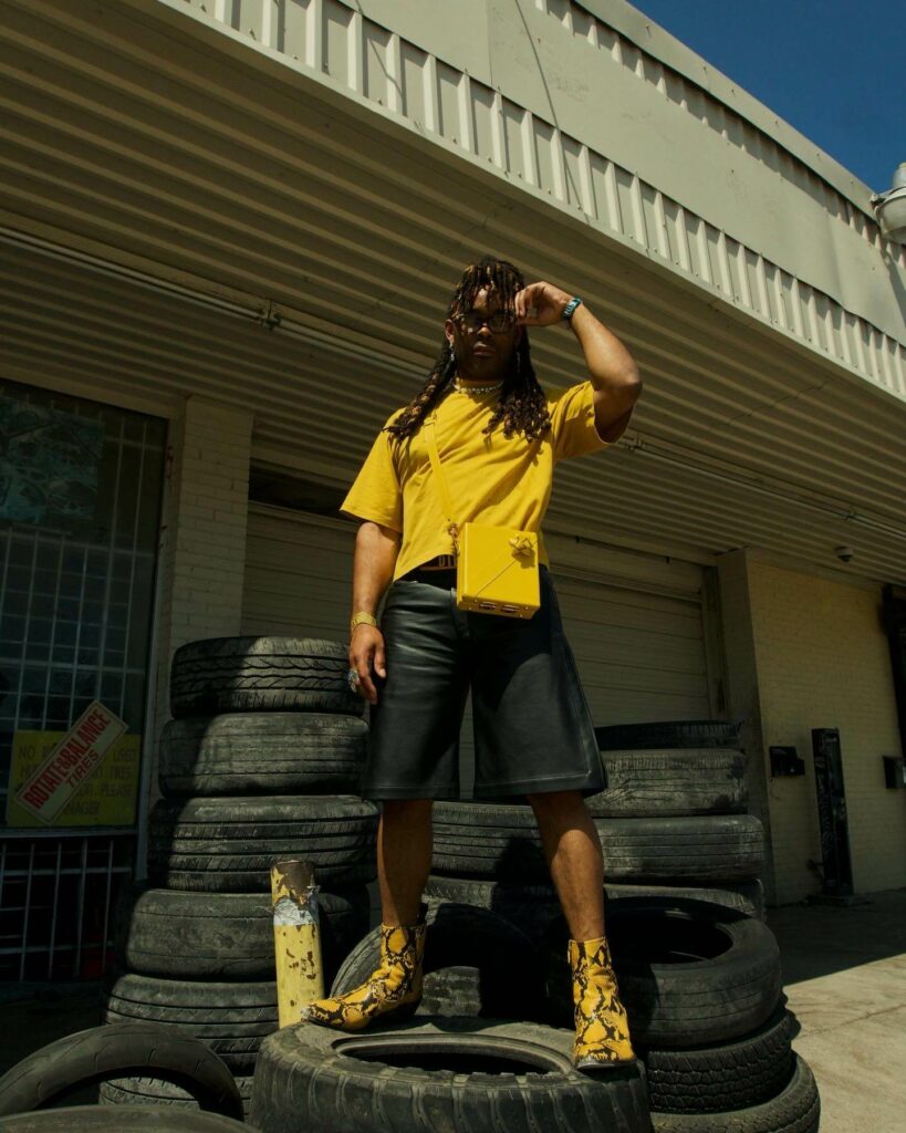 Young Fyre outside of the studio vibing in cowboy boots.